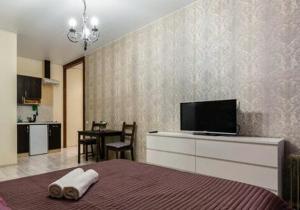 a bedroom with a bed with a flat screen tv at Apart Hotel Arka in Saint Petersburg