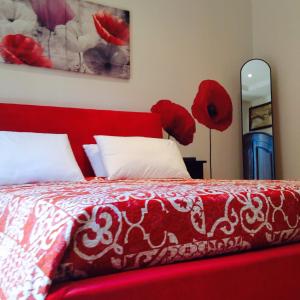 パレルモにあるA casa di Alice locazione turisticaの赤いベッド(赤と白のシーツ、赤の花付)