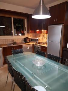 a kitchen with a blue table with chairs and a refrigerator at Villa Galleria in Perivolia