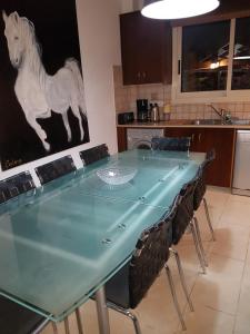 a dining room table with chairs and a painting of a horse at Villa Galleria in Perivolia