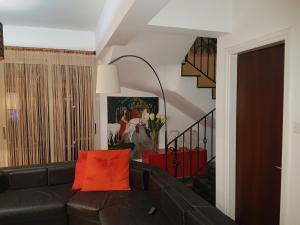 a living room with a black leather couch with an orange pillow at Villa Galleria in Perivolia