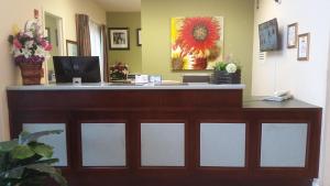 a reception desk in a waiting room with a flower painting on the wall at The Rutledge Inn in Luverne