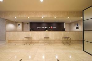 a lobby with a waiting area with two stools at Hotel JAL City Sendai in Sendai