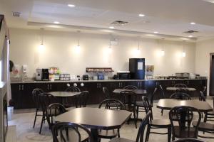 une salle à manger avec des tables et des chaises ainsi qu'une cuisine dans l'établissement Prairie Moon Inn & Suites Macklin, à Macklin