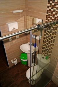 a small bathroom with a toilet and a sink at Hostal Casa de Los Taitas in Salento