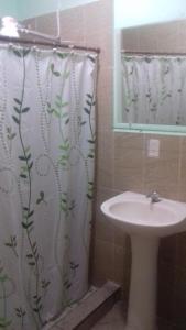 a bathroom with a sink and a shower curtain at Hostal Doña Marta in San Salvador