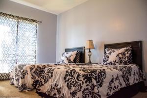 a bedroom with a bed with a black and white comforter at Tiara Del Sol in Ruidoso