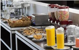 a kitchen counter with plates of food and orange juice at Arena Resort in Federación