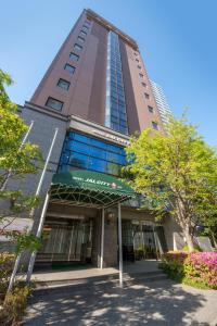 un edificio alto con un cartel delante en Hotel JAL City Sendai, en Sendai