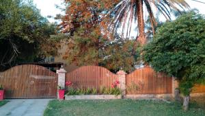 a fence in a yard with a palm tree at Cabañas Ensueño del Lago in Termas de Río Hondo