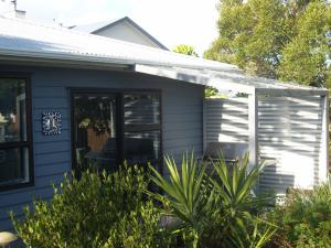a blue house with a sliding glass door at Beach B&B in Waihi Beach