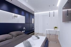 una camera da letto con pareti blu, un letto e un tavolo di P2 Kevin's Charming Houses ad Alghero