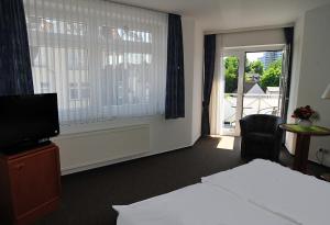 una camera d'albergo con letto, televisore e finestra di Hotel Stadt Reinfeld a Reinfeld