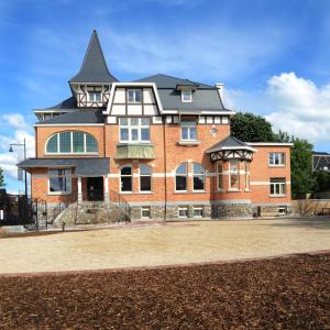 um grande edifício de tijolos vermelhos com um telhado preto em Charmehotel Villa Saporis em Hasselt