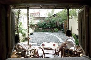 zwei Frauen, die auf einer Terrasse auf Stühlen sitzen in der Unterkunft Alley X Tainan in Tainan