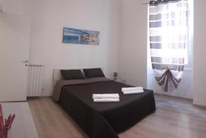 sypialnia z łóżkiem i dwoma ręcznikami na nim w obiekcie Alysia Apartment w Genui
