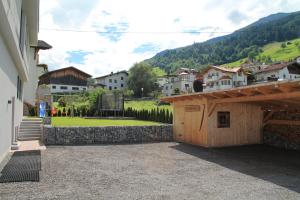 a building with a stone wall next to a village at Apart Alpinlive in Ladis