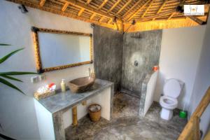 a bathroom with a sink and a toilet at Bambu Cottages in Gili Islands