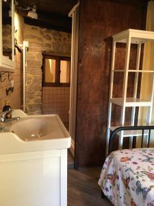 un bagno con un lavandino e un letto in una stanza di Alloggio del Grand Tour a Sonnino