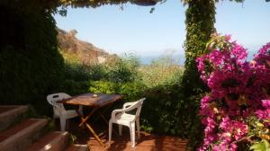 un tavolo e sedie seduti su un patio fiorito di Appartamenti Salato a Tropea