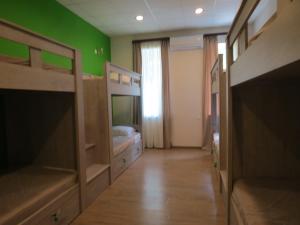 a bedroom with two bunk beds and a green wall at Hostel Your Home in Tbilisi City