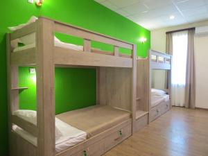 two bunk beds in a room with a green wall at Hostel Your Home in Tbilisi City