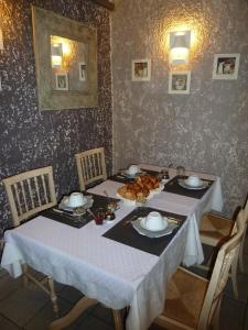 - une table à manger avec une nappe et des chaises blanches dans l'établissement Logis Hôtel Restaurant La Farigoule, à Sainte-Cécile-les-Vignes