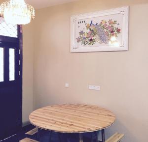 a wooden table in a room with a picture on the wall at Yunhe Titian Fengyin Inn in Yunhe