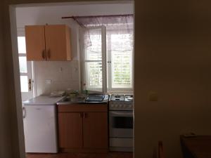 a kitchen with a stove and a sink and a window at Apartman Matić in Ston