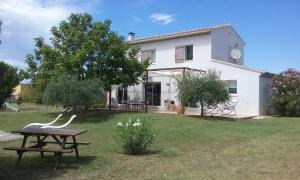 a white house with a picnic table in the yard at La bastide de Lily in Séguret