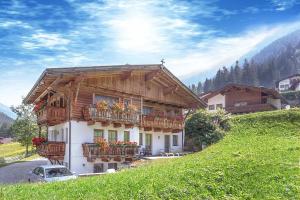 a house with balconies and flowers on a hill at Lärchenheim in Neustift im Stubaital