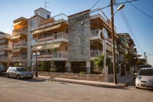 a large building with cars parked in front of it at Ikaros Apartments in Paralia Katerinis