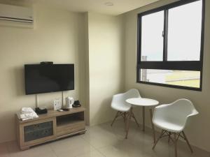 a living room with a tv and a table and chairs at Yin Mama Warm House in Yilan City
