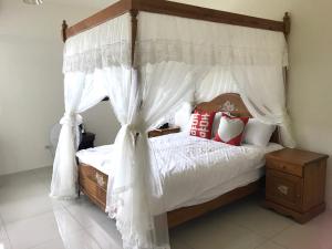 a bedroom with a canopy bed with red and white pillows at Yin Mama Warm House in Yilan City