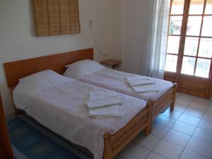 sypialnia z łóżkiem z ręcznikami w obiekcie Philippos Apartments w mieście Afissos