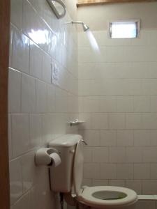 uma casa de banho branca com um WC e uma janela em Alojamiento El Cardon Tilcara em Tilcara