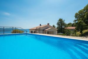 a large blue swimming pool in front of a house at Kuća za odmor Pavincica in Labin