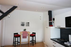 a kitchen with a small table and two stools at Seadrift Land-Apartments in Sankt Peter-Ording