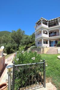 a large white house with a garden in front of it at Residence La Scala in Parga