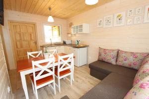 a small kitchen and dining room with a table and a couch at Czerwone Korale in Sarbinowo