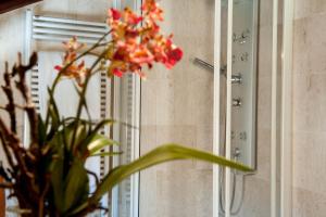 eine Vase voller Blumen vor einem Spiegel in der Unterkunft Hotel Flora in Cagliari