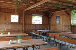 an empty restaurant with wooden tables and benches at Hotel Alex in Stammham