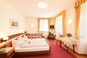 a hotel room with a bed and a couch at River Hotel Post in Chienes