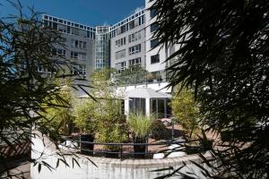 ein Gebäude mit einem Garten vor einem Gebäude in der Unterkunft Pearl Design Hotel - Frankfurt City in Frankfurt am Main