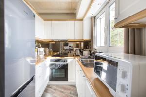 a kitchen with white cabinets and a large window at Villa Maya in Pallíni