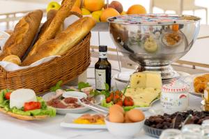 a table with bread and cheese and a basket of food at Cave Bianche Hotel in Favignana