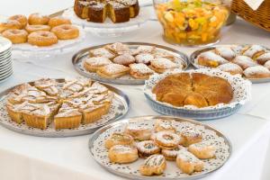 a table topped with plates of pastries and pies at Cave Bianche Hotel in Favignana +37 photos