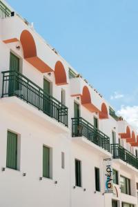 a building with balconies and a hotel sign at Ageri Hotel in Tinos