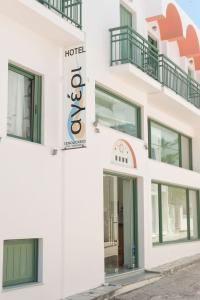 a white building with a sign on it at Ageri Hotel in Tinos