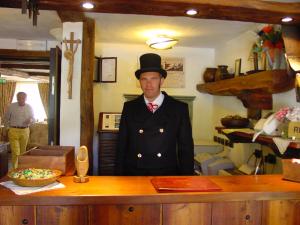 a man in a top hat standing next to a counter at Hotel Bellevue in Champoluc